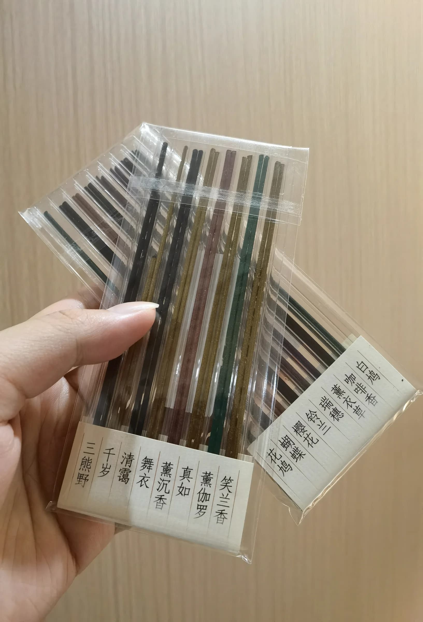 Two Kyukyodo eight-scent incense tasting assortments held in one hand